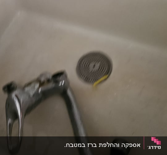 ברז מים מפורק המונח בתוך כיור מטבח